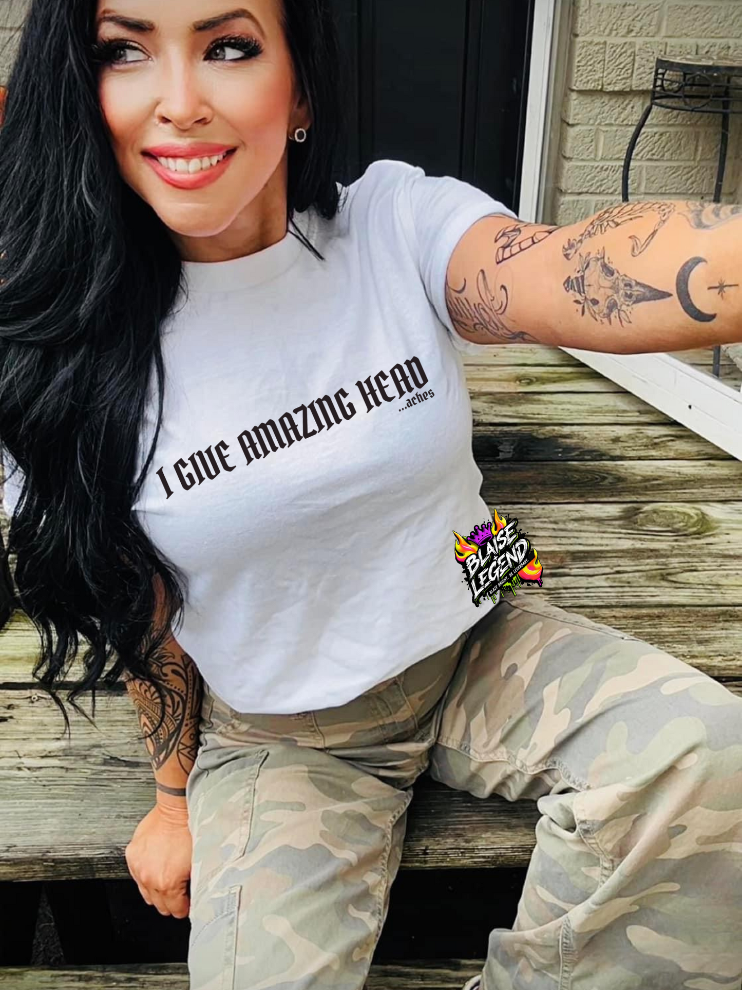 Woman wearing a white Comfort Colors t-shirt with the bold and humorous text 'I Give Amazing Head...aches,' styled with edgy, sarcastic flair.