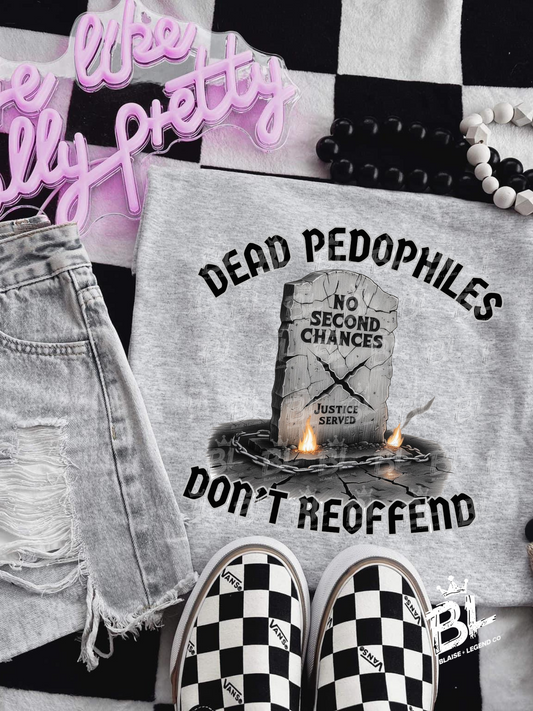 Dead Pedophiles Don't Reoffend graphic t-shirt featuring a cracked tombstone design with fire and bold text, available in black, white, ash grey, and black/red tie-dye.