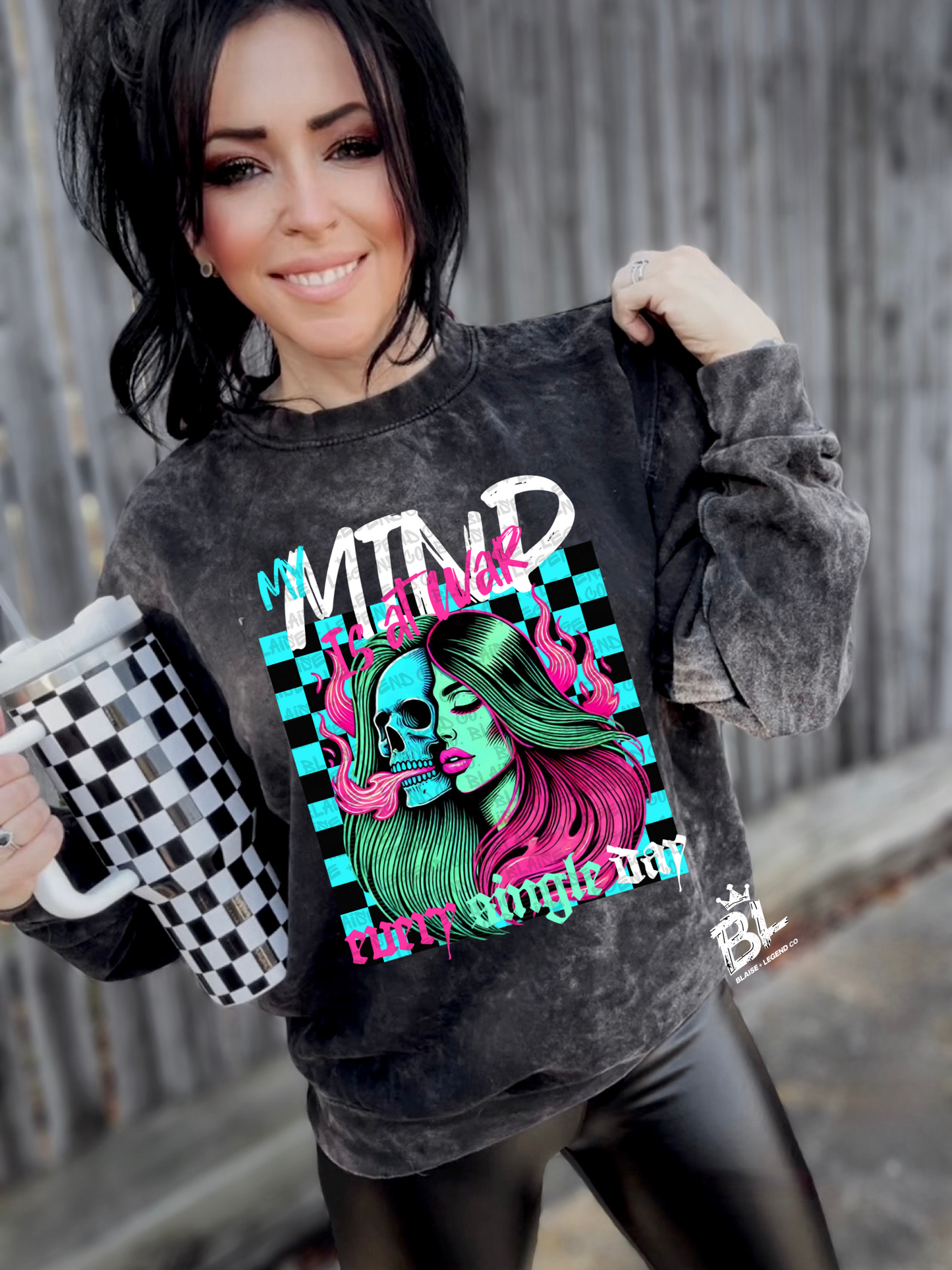 Woman wearing "My Mind Is At War" neon crewneck sweatshirt featuring skull and bold graphic design.