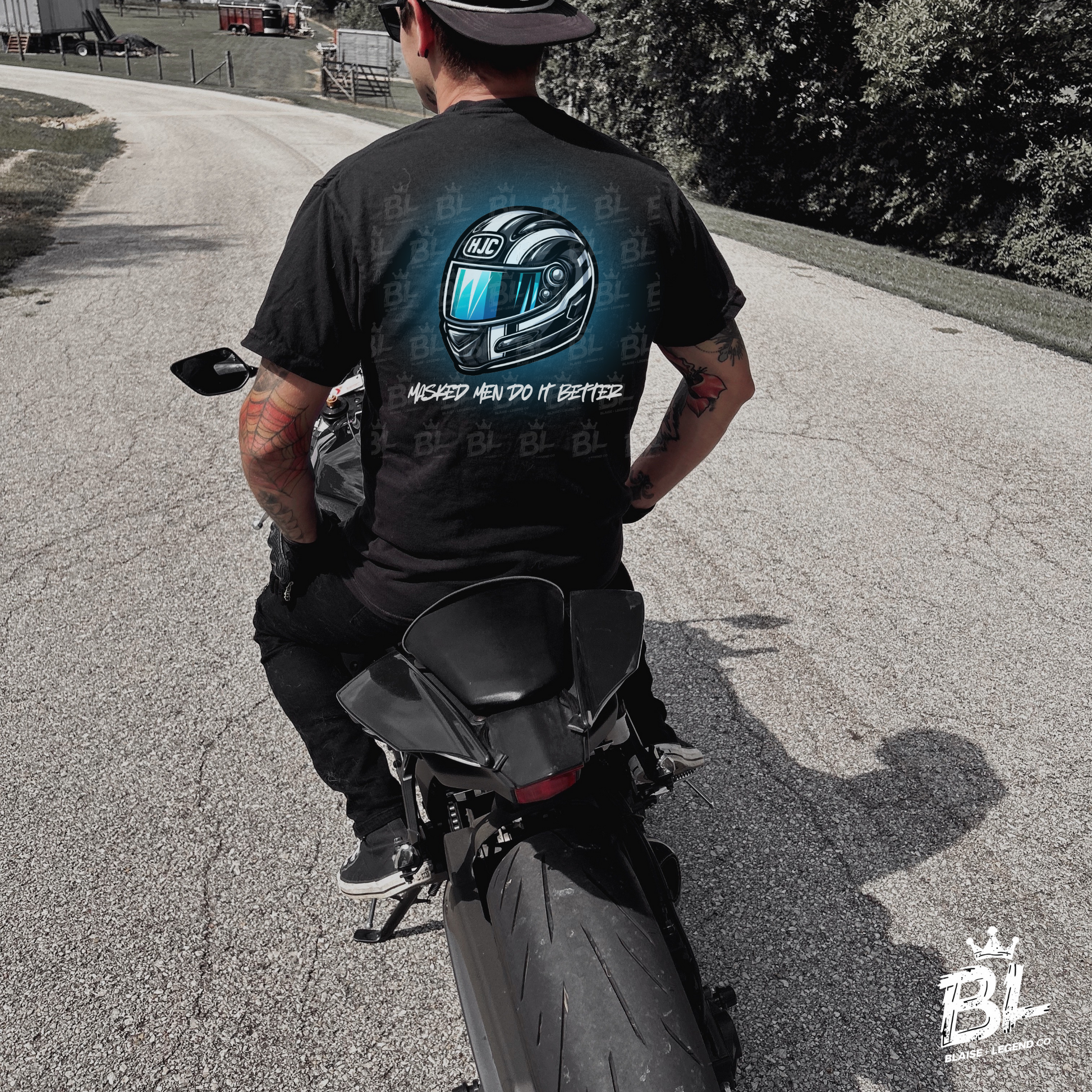 Black t-shirt with 'Masked Men Do It Better' in graffiti font and motorcycle helmet graphic